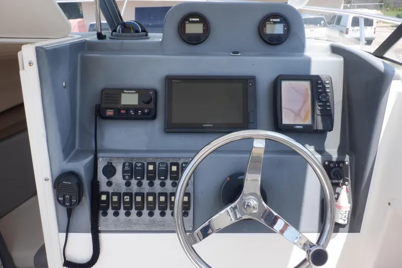 Slide: The Image of 2015 Seaswirl Striper 220 Walkaround dashboard with steering wheel and navigation instruments. - 22