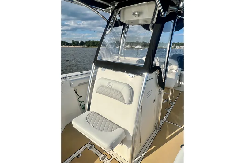 Slide: The Image of 2011 Key West 244 Center Console boat interior with seating and console, on a sunny day. - 11