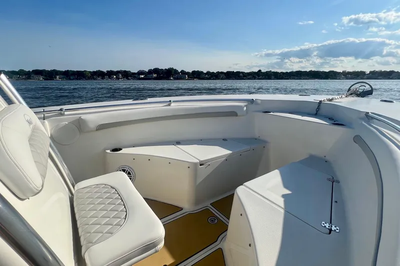 Slide: The Image of 2011 Key West 244 Center Console boat interior with seating, on a sunny day by the water. - 8