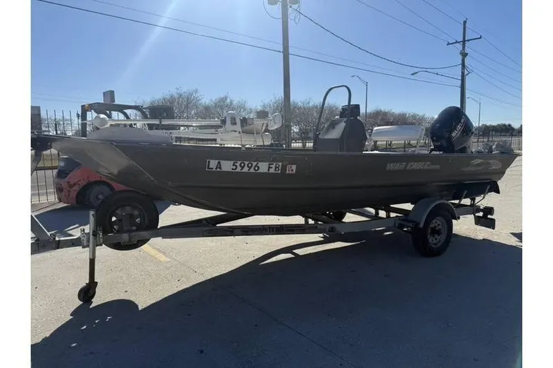 Slide: The Image of 2000 War Eagle 18ft CC boat on trailer, parked outdoors. - 3