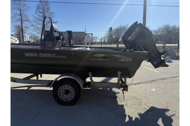 Slide: The Image of 2000 War Eagle 18ft CC boat with Suzuki outboard motor on trailer. - 5