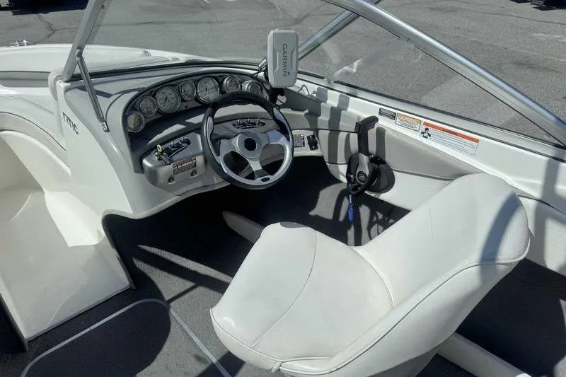 Slide: The Image of 2008 Bayliner Element F18 boat interior with white seating and steering console. - 7