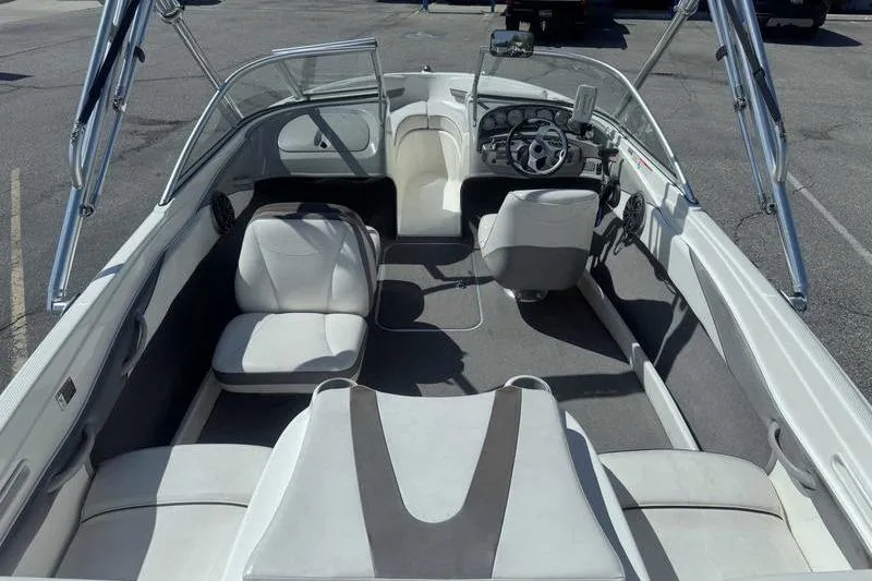 Slide: The Image of 2008 Bayliner Element F18 boat at dealership, rear view with blue building background. - 8