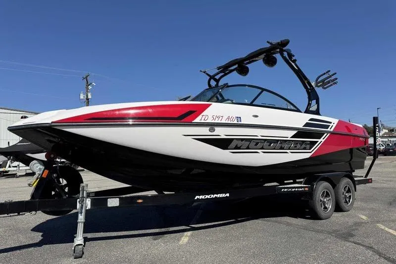 The Image of 2016 Moomba Mojo boat on trailer, red and black design, parked outdoors. - 0