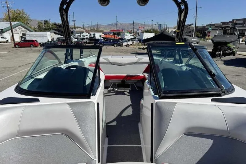 Slide: The Image of 2016 Moomba Mojo boat interior with open windshield, parked in a lot. - 11