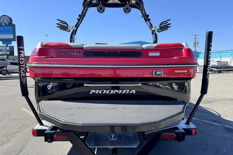 Slide: The Image of 2016 Moomba Mojo boat with red and black design on a trailer, rear view. - 4