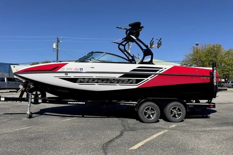 Slide: The Image of 2016 Moomba Mojo boat interior with gray and red seating, steering wheel, and dashboard. - 6