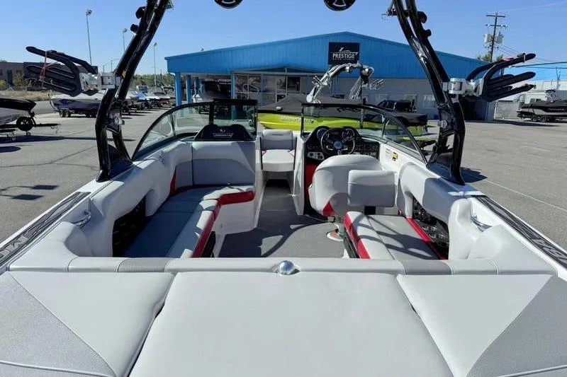 Slide: The Image of 2016 Moomba Mojo boat interior with seating and dashboard, displayed at a dealership. - 7