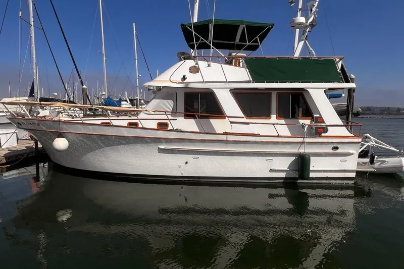 The Image of 1981 Cheer Men PT 38 Europa yacht docked at marina, featuring green canopy and classic design. - 0