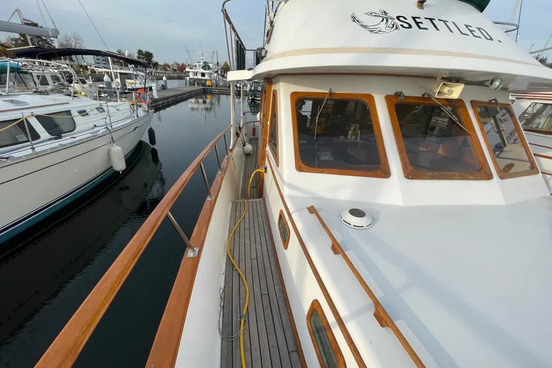 Slide: The Image of 1981 Cheer Men PT 38 Europa yacht docked at marina, featuring wooden railings and large windows. - 14