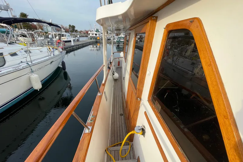 Slide: The Image of 1981 Cheer Men PT 38 Europa yacht docked at marina, showcasing wooden details and nearby boats. - 15