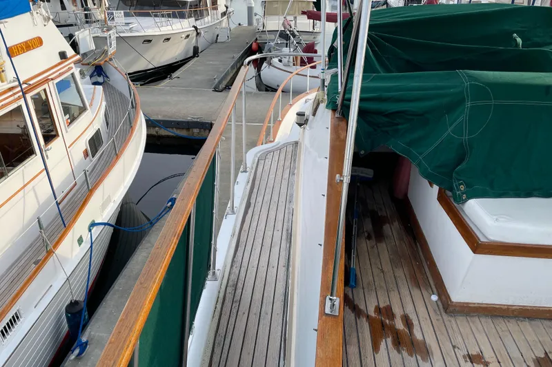 Slide: The Image of 1981 Cheer Men PT 38 Europa yacht docked, featuring wooden deck and green cover. - 16