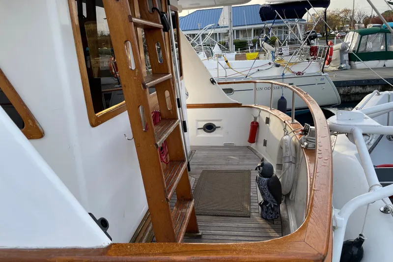 Slide: The Image of 1981 Cheer Men PT 38 Europa boat deck with wooden ladder and docked sailboats. - 22