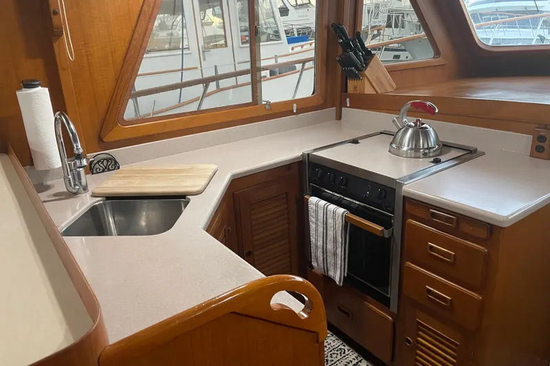 Slide: The Image of 1981 Cheer Men PT 38 Europa yacht kitchen with stove, sink, and wooden cabinetry. - 29
