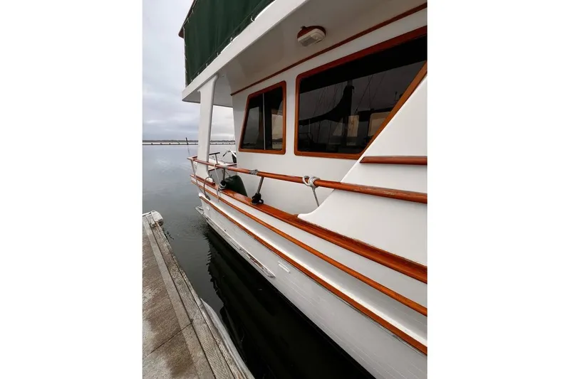 Slide: The Image of 1981 Cheer Men PT 38 Europa yacht docked, showcasing wooden railings and windows. - 4
