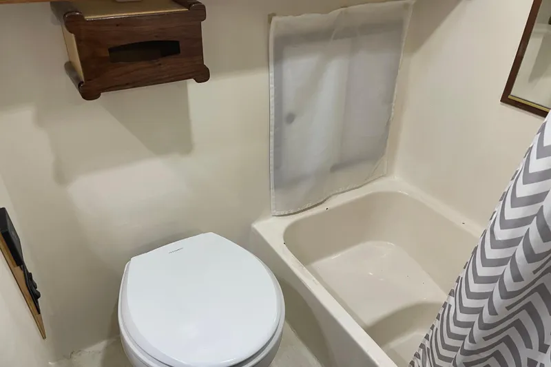 Slide: The Image of Compact bathroom in 1981 Cheer Men PT 38 Europa, featuring toilet and bathtub with chevron shower curtain. - 45