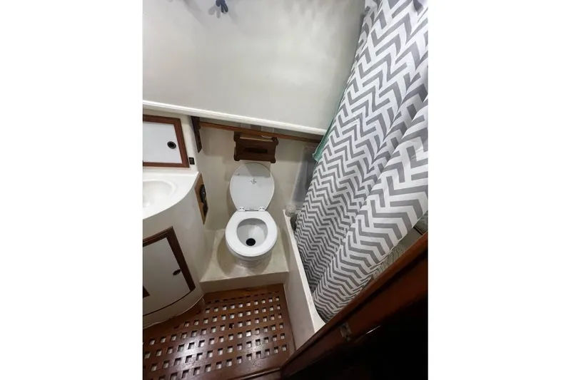 Slide: The Image of 1981 Cheer Men PT 38 Europa bathroom with toilet, sink, and chevron shower curtain. - 50