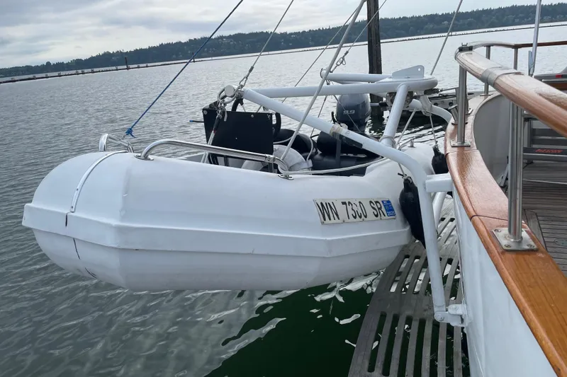 Slide: The Image of 1981 Cheer Men Marine PT 38 Europa with dinghy on davits, docked on calm water. - 6