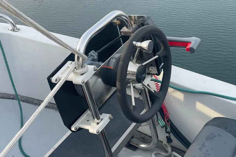 Slide: The Image of Steering wheel of 1981 Cheer Men PT 38 Europa boat, docked on calm water. - 9