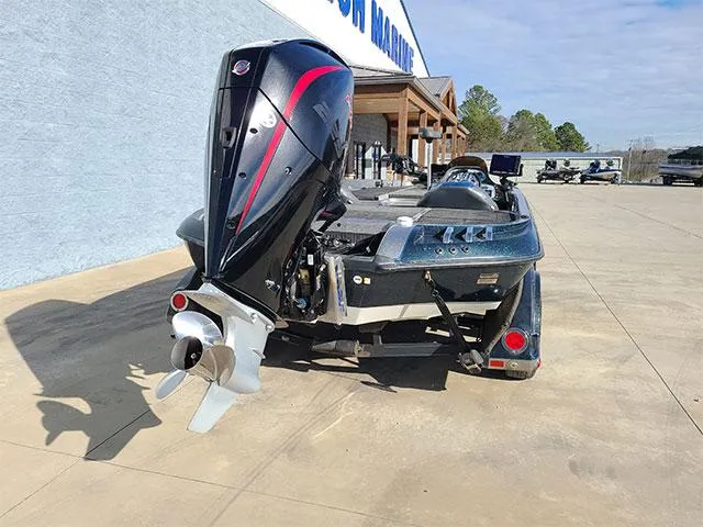 Slide: The Image of 2006 Ranger Z19 Comanche boat with outboard motor, parked outside a marine dealership. - 11