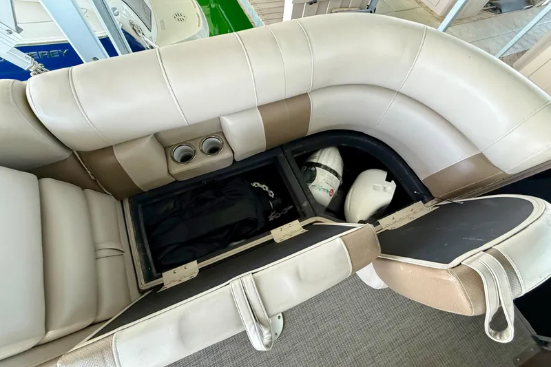 Slide: The Image of 2017 Bentley Pontoons 223 Cruise interior storage with beige seating and cup holders. - 13