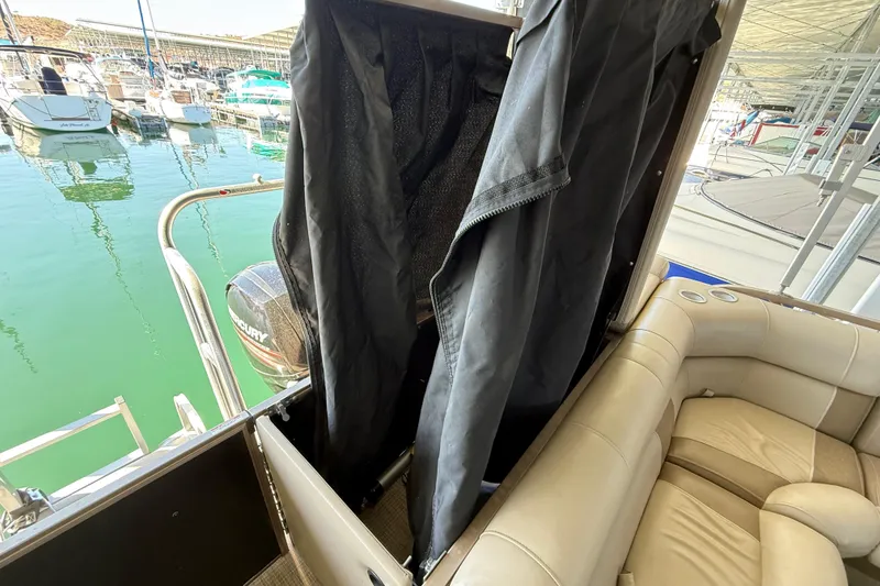 Slide: The Image of 2017 Bentley Pontoons 223 Cruise interior with seating and privacy curtain, docked at marina. - 18