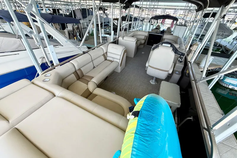 Slide: The Image of 2017 Bentley Pontoons 223 Cruise interior with beige seating and helm, docked in marina. - 4