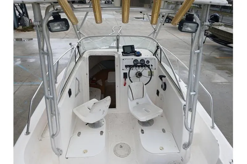 Slide: The Image of 1999 Century 2300 Walk-Around boat interior with steering wheel and seating. - 6