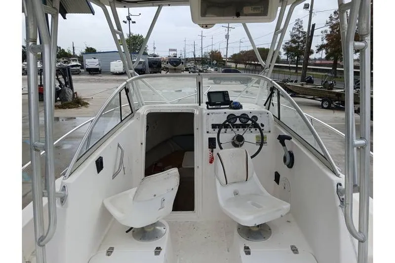 Slide: The Image of 1999 Century 2300 Walk-Around boat interior with steering console and seating. - 7