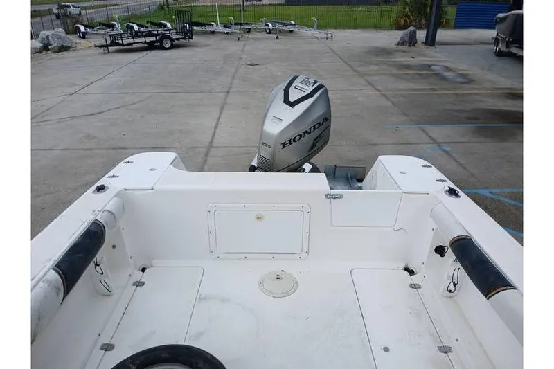 Slide: The Image of 1999 Century 2300 Walk-Around boat with Honda outboard motor in a parking area. - 8