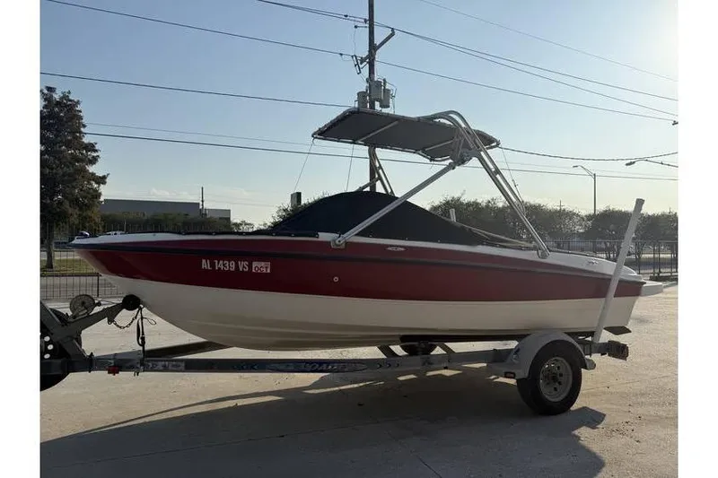 Slide: The Image of 2008 Bayliner 185 Bowrider on trailer, red and white, parked outdoors. - 2