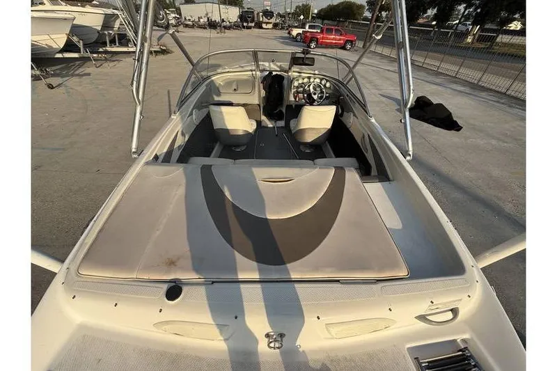 Slide: The Image of 2008 Bayliner 185 Bowrider boat interior, featuring seating and steering wheel, parked outdoors. - 5