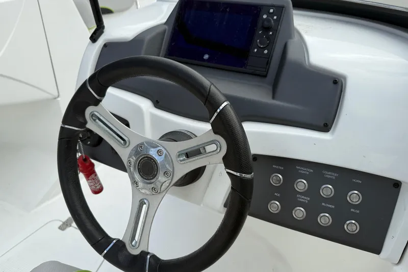 Slide: The Image of Steering wheel and control panel of a 2019 Tahoe 700 boat. - 13