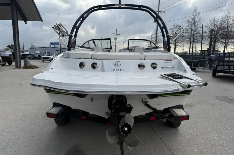 Slide: The Image of 2019 Tahoe 700 boat rear view, showcasing sleek design and powerful motor in a marina setting. - 6