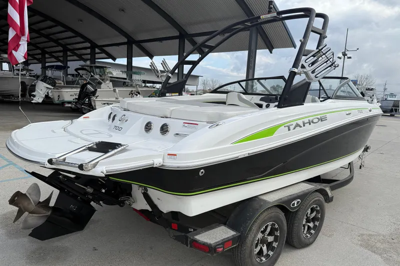 Slide: The Image of 2019 Tahoe 700 boat on trailer, displayed in a marina setting. - 7