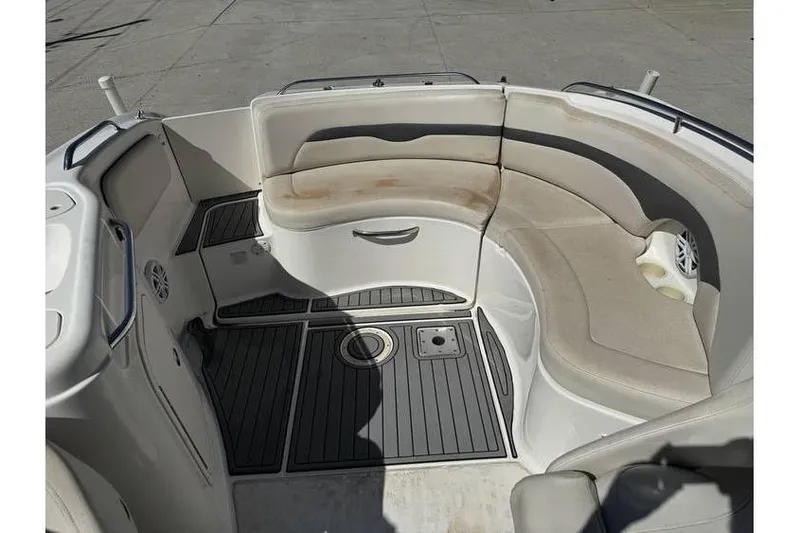 Slide: The Image of 2004 Chaparral Sunesta 254 boat interior with curved seating and non-slip flooring. - 11