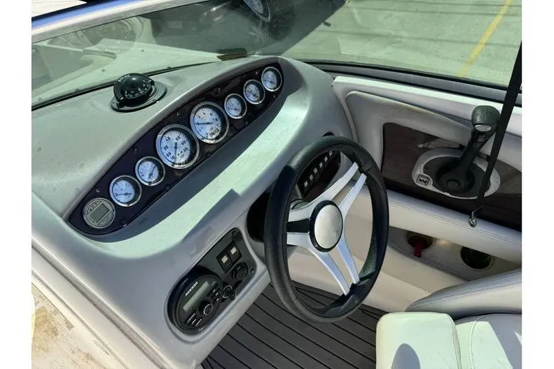 Slide: The Image of 2004 Chaparral Sunesta 254 boat dashboard with gauges and steering wheel. - 13