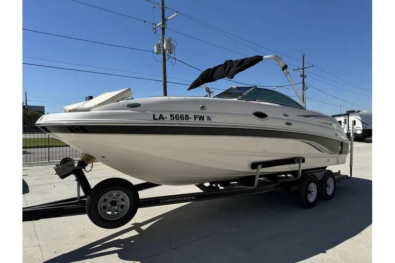 Slide: The Image of 2004 Chaparral Sunesta 254 boat on trailer, parked outdoors under clear sky. - 3