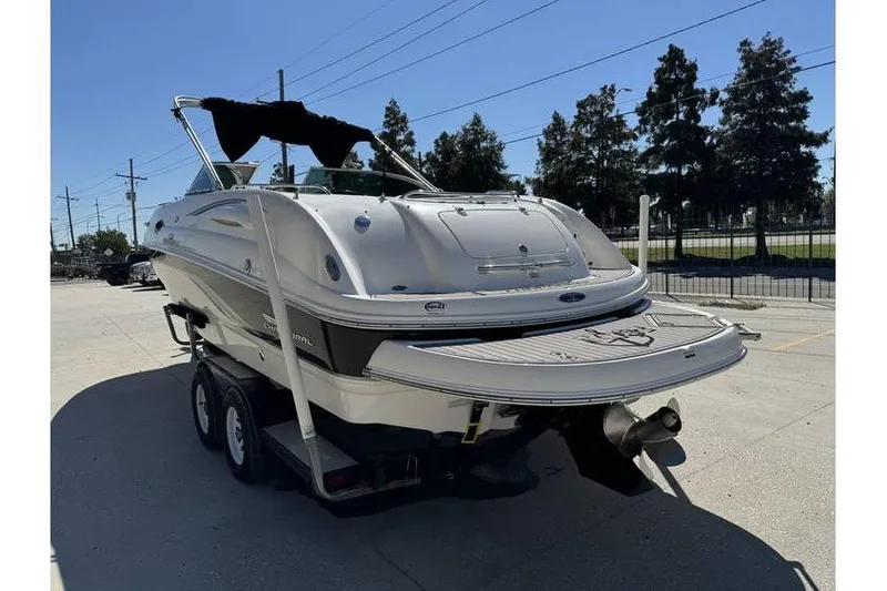 Slide: The Image of 2004 Chaparral Sunesta 254 boat on trailer, parked outdoors under clear sky. - 5