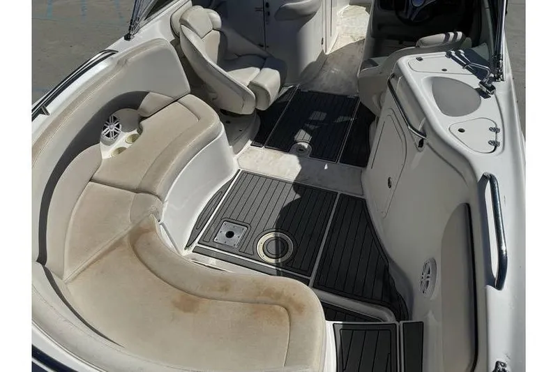 Slide: The Image of 2004 Chaparral Sunesta 254 boat interior with seating and sink, featuring beige upholstery. - 9