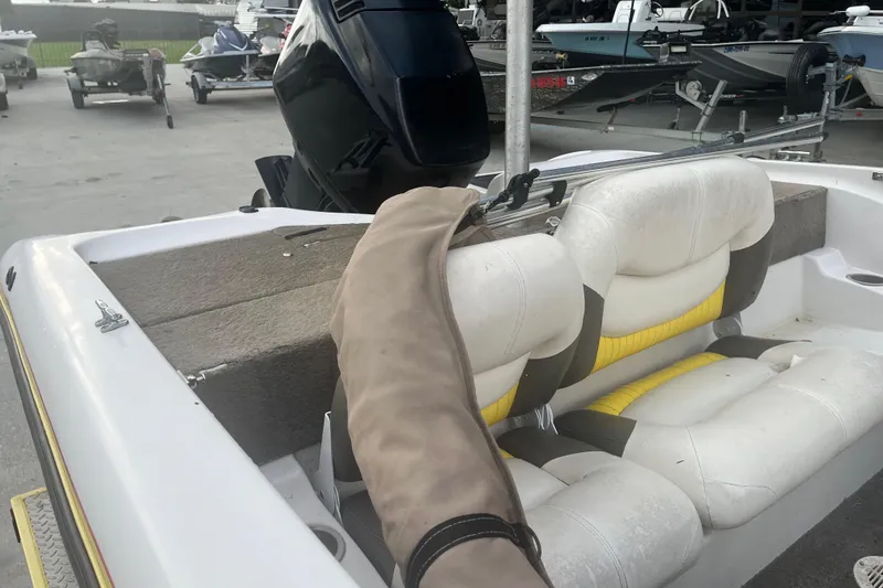 Slide: The Image of 2006 Nitro 189 Sport boat interior with white and yellow seating, docked at marina. - 10