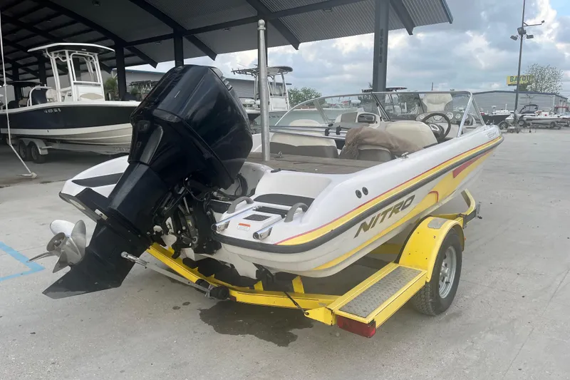 Slide: The Image of 2006 Nitro 189 Sport boat on yellow trailer, parked in marina. - 7