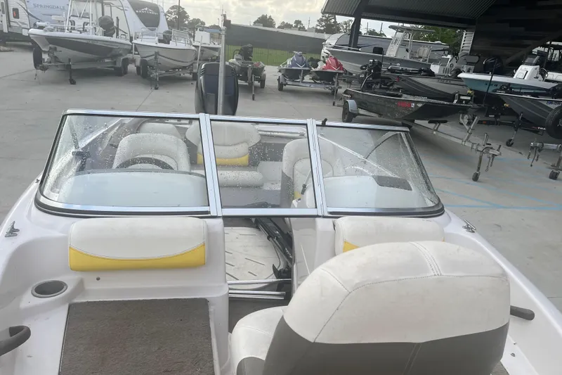Slide: The Image of 2006 Nitro 189 Sport boat with white and yellow interior, parked in a marina. - 8