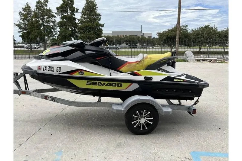 Slide: The Image of 2014 Sea-Doo Wake 155 jet ski on trailer, parked outdoors. - 4