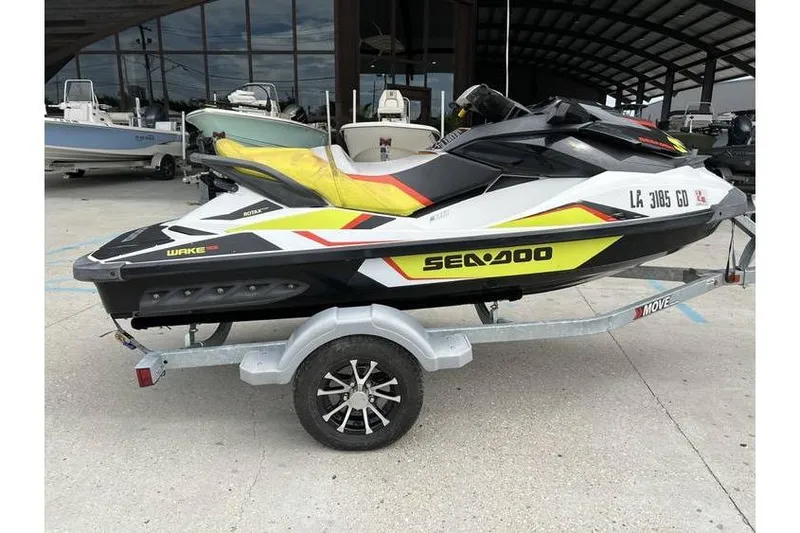 Slide: The Image of 2014 Sea-Doo Wake 155 jet ski on trailer, parked outdoors. - 5