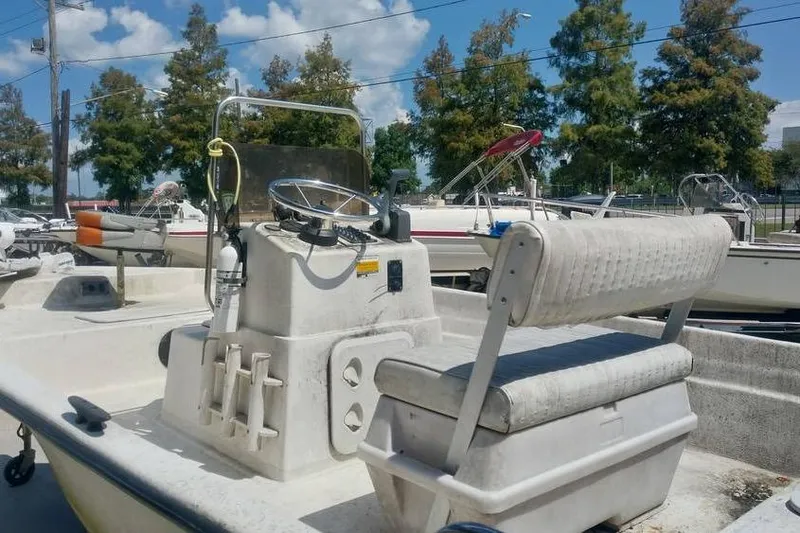 Slide: The Image of 2007 SeaStar 18cc boat with seating and steering console, parked outdoors under a clear sky. - 4