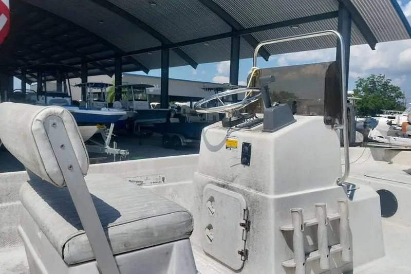 Slide: The Image of 2007 SeaStar 18cc boat interior with steering console and seating, parked under a metal canopy. - 5