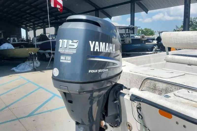 Slide: The Image of Yamaha 115 four-stroke outboard motor on a 2007 SeaStar 18cc boat at a marina. - 6