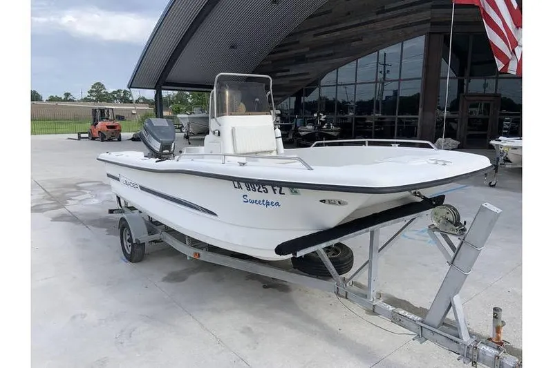 The Image of 2000 Leader 180 Catamaran on trailer, parked outdoors near a modern building. - 0