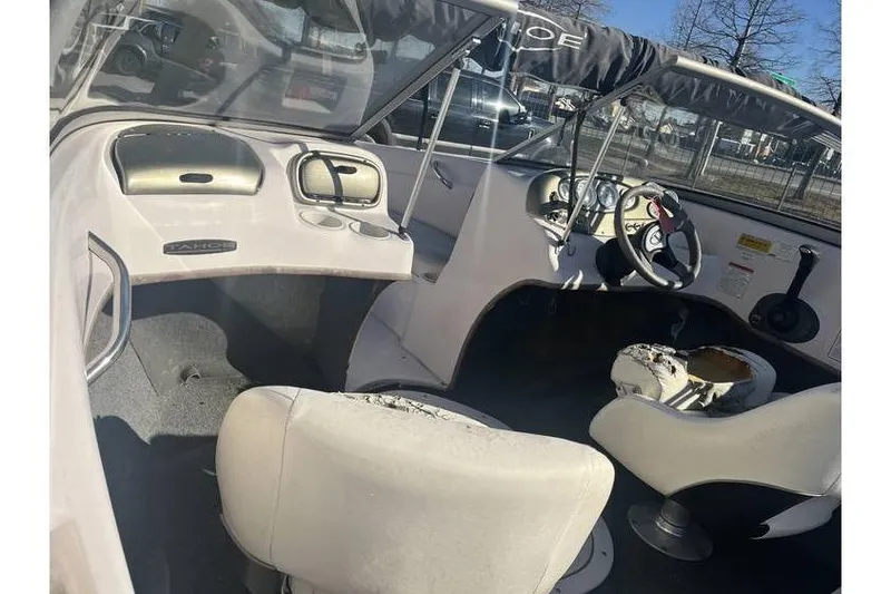 Slide: The Image of Interior of a 2006 Tahoe 206 boat with worn seats and steering wheel. - 11
